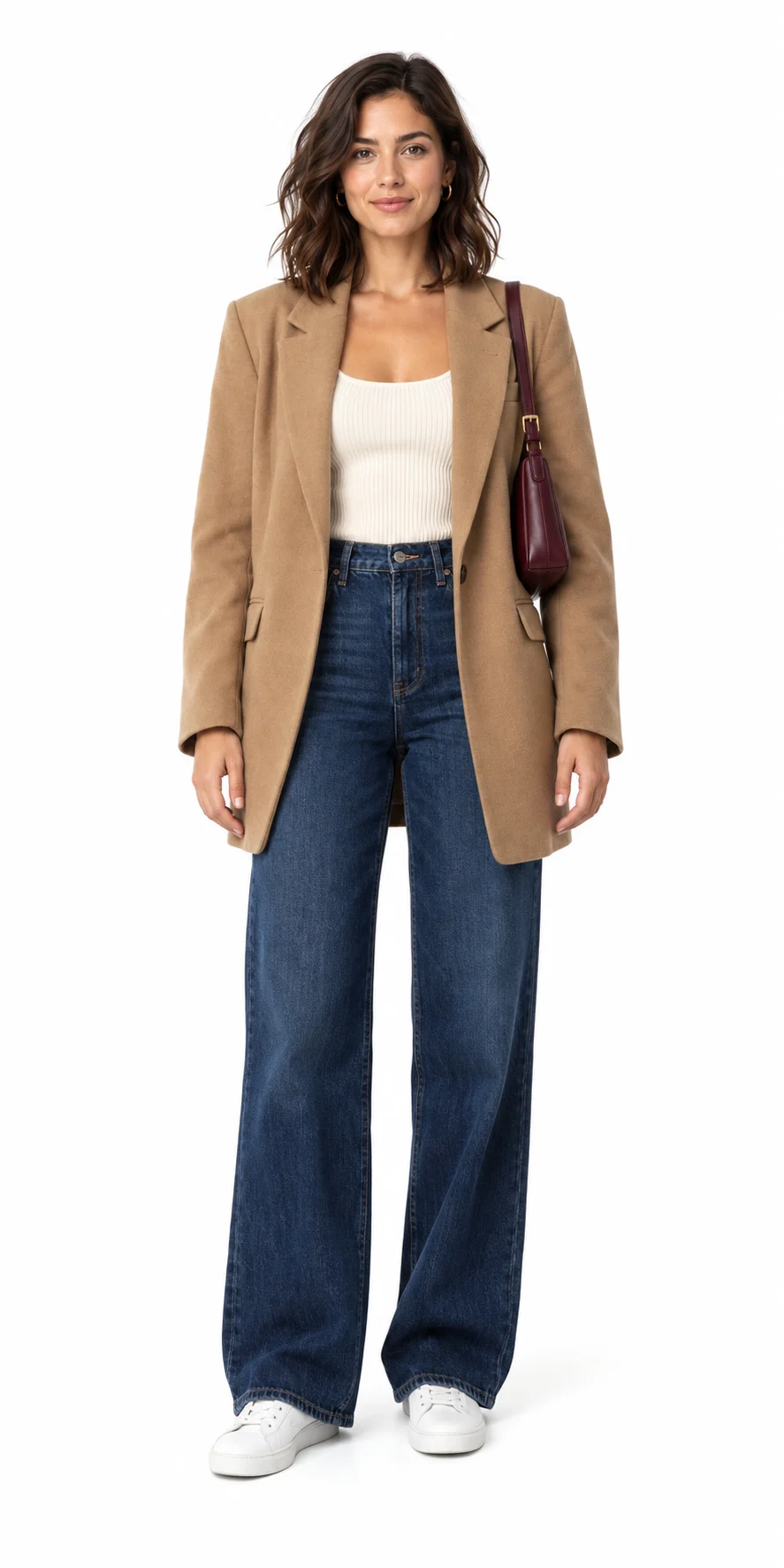 Modelo con blazer camel amplio, camiseta de tirantes acanalada color crema, jeans oscuros anchos, zapatillas blancas y bolso burdeos
