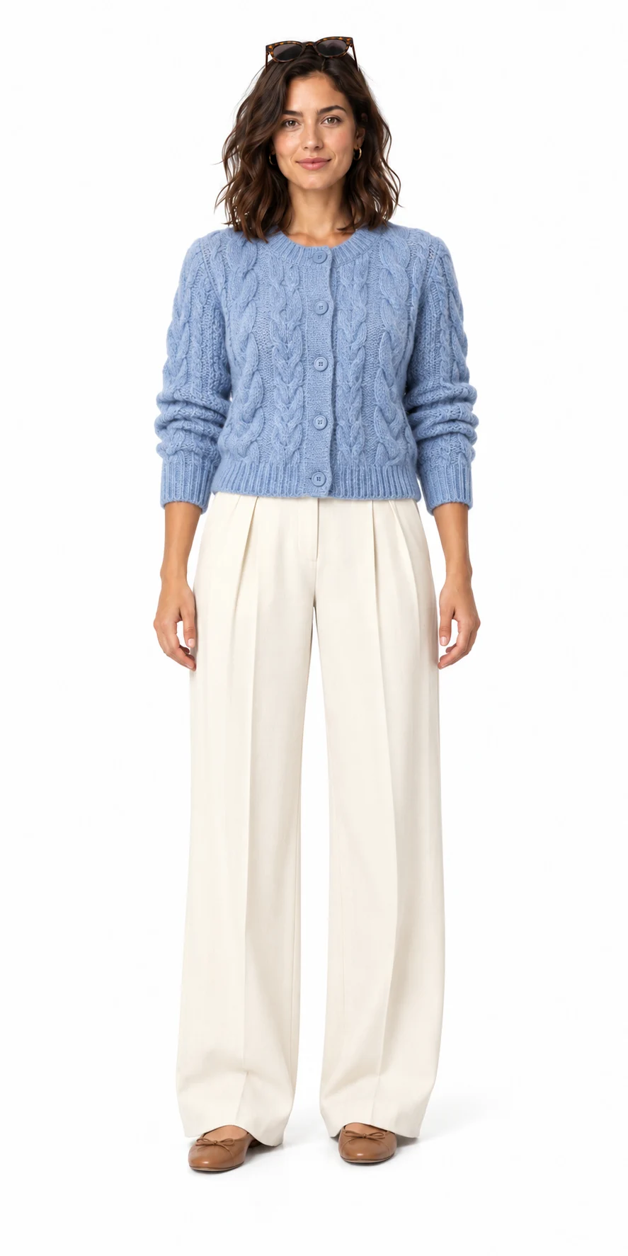 Modelo con cárdigan azul claro de punto trenzado, pantalones anchos con pinzas color crema y bailarinas marrón claro